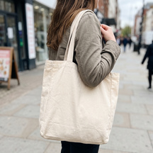 The tote carried on a shoulder along a sidewalk